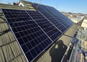 20260612_06 - 東京都の補助金制度を活用した太陽光・蓄電池・V2H設置サポート|ソルト公式 Rooftop solar panels installed on a sloped residential roof with scaffolding nearby under a clear blue sky