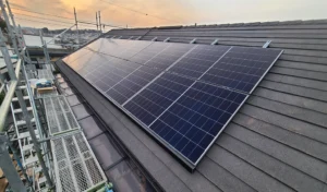 Solar panels mounted on a sloped roof with scaffolding nearby during sunset, powering a building switch to clean energy (informative)