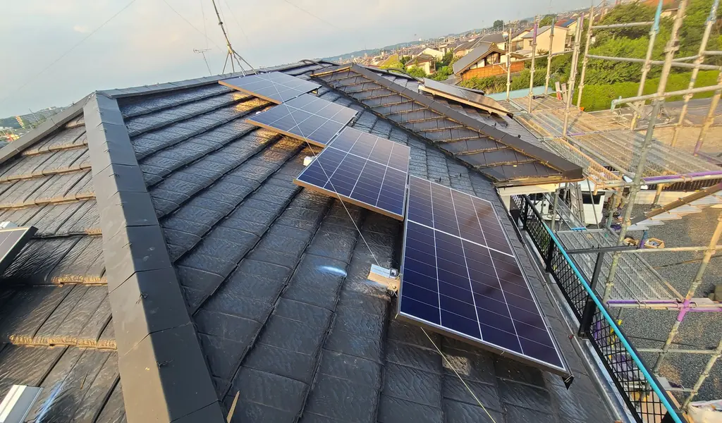 八王子市の寄棟屋根の西側の面に並べた太陽光パネルと工事用の足場